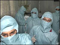 Doctors, wearing protective suits, are seen inside a special ward as they examine a suspected swine flu patient in Ahmedabad June 18